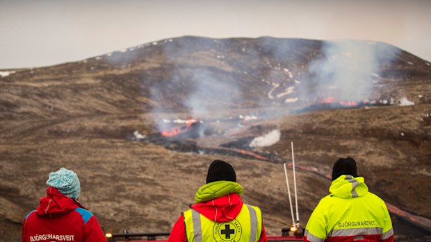 Members of the Search and Rescue Team, Bjorgunasveit look at a new fissure on a volcano on the Reykjanes Peninsula in southwestern Iceland.