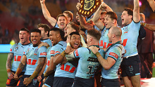 NSW players celebrate with the shield after the Origin decider. 