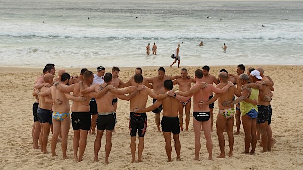 A mental health mens group called WNOW gather together at Bondi Beach near the crime scene of Sunday night's mass shooting.