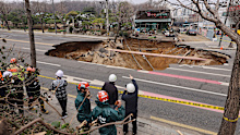 Rescue authorities inspect a sinkhole on an intersection in Seoul, South Korea, Tuesday, March 25, 2025. (Suh Dae-hyun/Yonhap via AP)