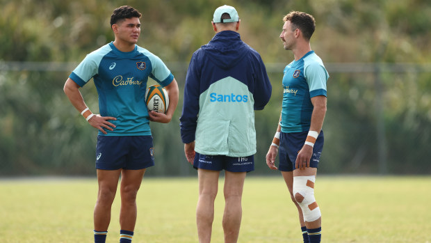 Joe Schmidt talks with Noah Lolesio and Nic White during a Wallabies training session.