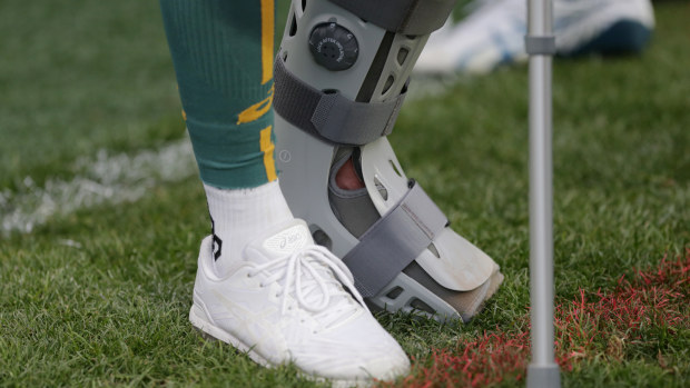 Quade Cooper in a moon boot and on crutches.