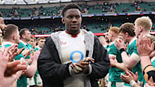 Maro Itoje of England walks through a guard of honour formed by players of Ireland.