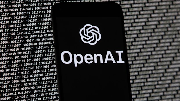 The OpenAI logo appears on a mobile phone in front of a computer screen with random binary data, March 9, 2023, in Boston. (AP Photo/Michael Dwyer, File)
