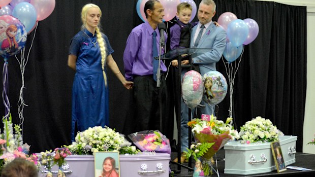 Renise and Troy Young, with their son Aige, stand with the two tiny coffins for their daughters Taya, 4, and Patricia, 3, who drowned in the backyard pool of their home in Loganholme, Brisbane. (AAP)