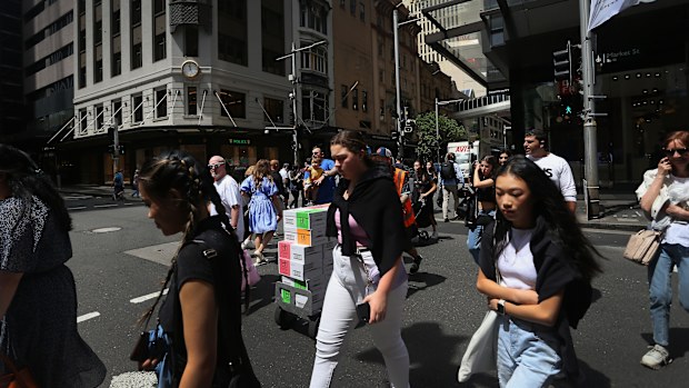 Pedestrians move across Market Street in Sydney, Australia. 