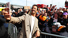 Daniel Ricciardo takes a photo with fans as he arrives at the paddock ahead of the 2024 British Grand Prix.