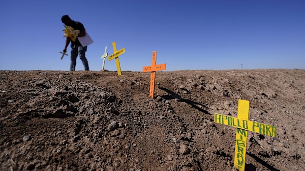 Hugo Castro leaves crosses at the scene of a deadly crash.