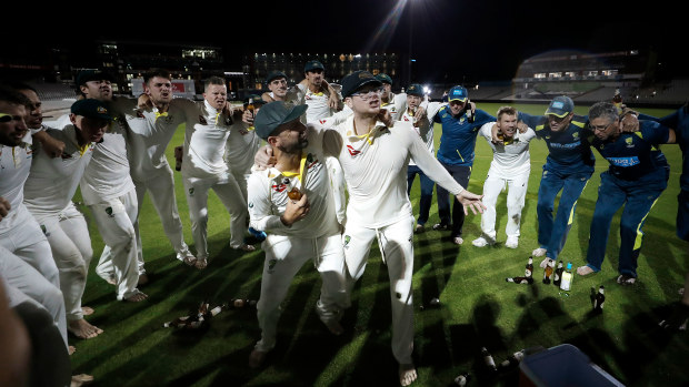 Nathan Lyon and Steve Smith belt out the victory song together in the middle of the Old Trafford pitch, surrounded by teammates.