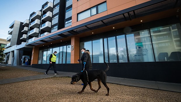 Staff from DHHS (Department of Health and Human Services Victoria) are seen walking the dogs of residents from the Ariele Apartments in Maribyrnong in Melbourne.