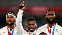 Jerry Tuwai of Fiji sings on the podium with his teammates after receiving their gold medals.