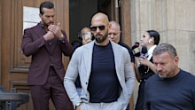 Andrew Tate, center, and his brother Tristan, left, walk outside the Court of Appeals building, after a hearing, in Bucharest, Romania, Wednesday, Sept. 4, 2024.  