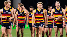 Adelaide Crows players walk from the ground looking dejected in 2019.