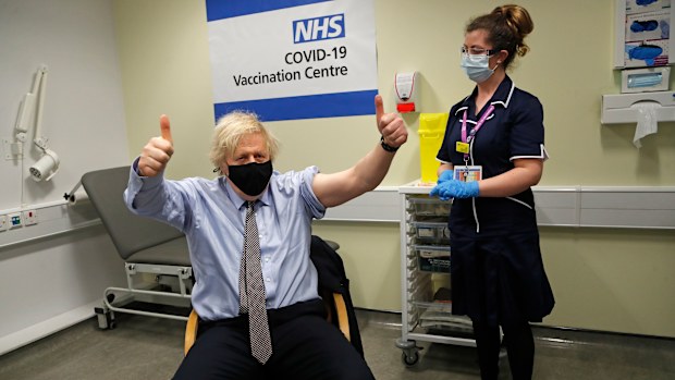 Britain's Prime Minister Boris Johnson gestures after receiving the first dose of AstraZeneca vaccine