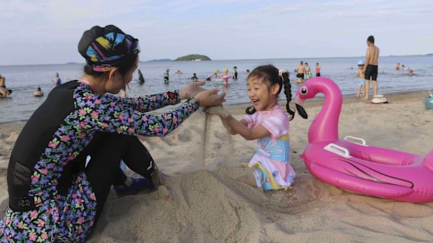 A girl and her mother play on the beach at the the Wonsan-Kalma resort in Wonsan, Kangwon Province, North Korea, Tuesday, July 1, 2025. (AP Photo/Jon Chol Jin)