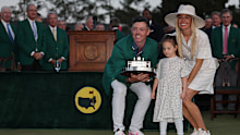 Rory McIlroy of Northern Ireland poses with daughter Poppy and wife Erica Stoll holding the Masters trophy during the Green Jacket Ceremony after winning the 2025 Masters Tournament at Augusta National Golf Club on April 13, 2025 in Augusta, Georgia. (Photo by Michael Reaves/Getty Images)