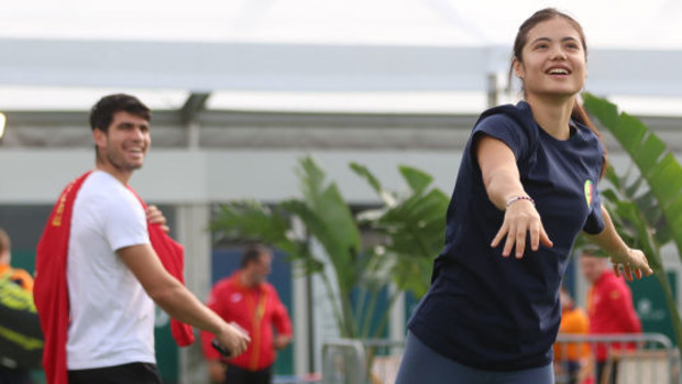 Carlos Alcaraz of Spain interacts as Emma Raducanu of Great Britain warms up.