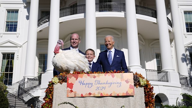 President Joe Biden, right, stands with John Zimmerman, left, chair of the National Turkey Federation, his son Grant Zimmerman, center, and the national Thanksgiving turkey, Peach, during a pardoning ceremony on the South Lawn of the White House in Washington, Monday, Nov. 25, 2024. (AP Photo/Susan Walsh)
