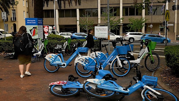 Pedestrians walk past e-bikes near the NSW State Library in Sydney.
