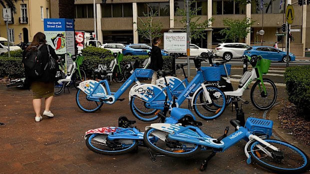 Pedestrians walk past e-bikes near the NSW State Library in Sydney.