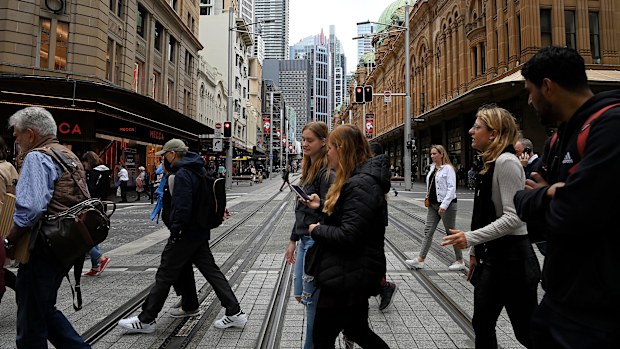People cross over Pitt street as they walk along Market street in the CBD of Sydney.