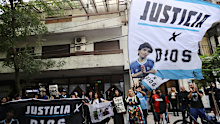 Fans of late Argentinian football legend wait outside the courthouse on March 11, 2025 in San Isidro, Argentina. Maradona suffered a heart attack and died while recovering from a head surgery to remove a blood clot on November 25, 2020. Seven members of his medical staff have been accused of negligence and will face a trial under the charge of homicide. (Photo by Marcos Brindicci/Getty Images)