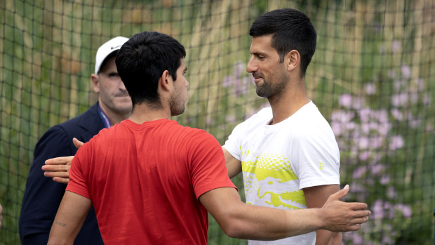 Carlos Alcaraz of Spain and Novak Djokovic of Serbia embrace during court changeover as players train on the practice courts in preparation for the Wimbledon Lawn Tennis Championships at the All England Lawn Tennis and Croquet Club at Wimbledon on July 02, 2023, in London, England. (Photo by Tim Clayton/Corbis via Getty Images)