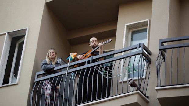 A man plays guitar on the balcony of his home during a flash mob launched throughout Italy to bring people together.