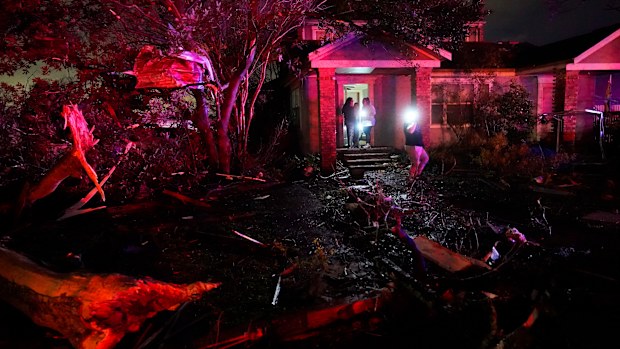 People survey damage in Arabi, Louisiana after power lines were ripped down and debris scattered amid the tornado. 