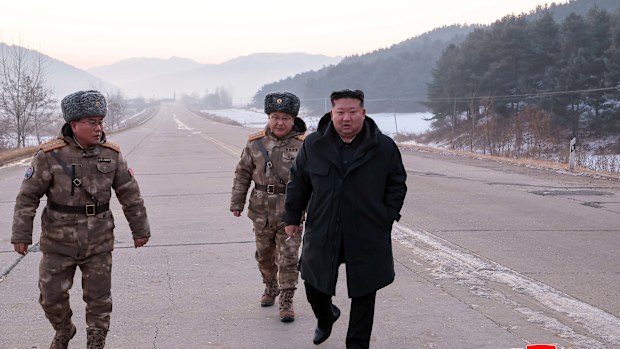 In this photo provided by the North Korean government, leader Kim Jong Un walks on a road as he inspects test-flights of hypersonic missiles, in Pyongyang.