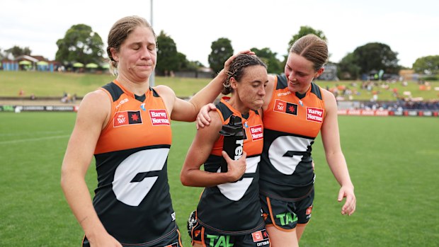 Aliesha Newman of the Giants is embraced by Katherine Smith and Jessica Doyle.