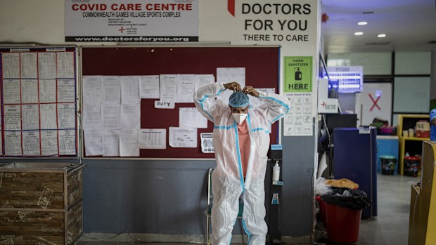 A paramedic prepares for duty at a makeshift COVID-19 care center at an indoor sports stadium, in New Delhi, India, 