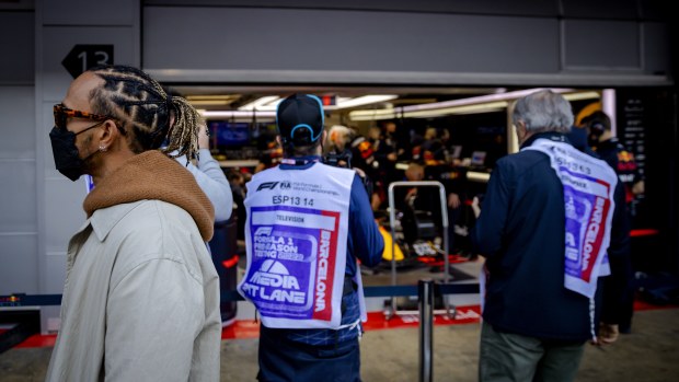 Mercedes' Lewis Hamilton takes a look at Red Bull Racing's pit box during the first day of testing at Spain's Circuit de Barcelona-Catalunya.