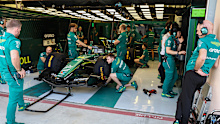 Aston Martin boss Adrian Newey observes as mechanics work on the AMR26 during F1 testing.