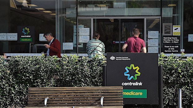 People wait outside a Services Australia outlet