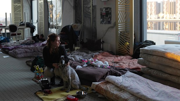 SUCEAVA, ROMANIA - [MARCH 18]: A young woman who fled the conflict in Ukraine holds her dog as she looks out the window in the ballroom in Mandachi Hotel and Spa, that was turned into a temporary shelter, on March 18, 2022 in Suceava, Romania. Ukrainian refugees continue to cross the border into Romania since Russia's invasion on February 24, some 500,000 Ukrainian citizens have entered Romania, with the majority reportedly making their way onto other countries in Western Europe.  (Photo by Andr