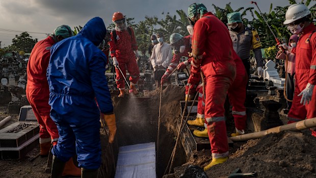 Volunteers conduct a burial the body of a woman suspected to have died from COVID-19 while isolating at home in Yogyakarta, Indonesia. 