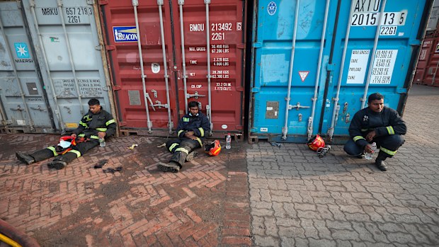 Exhausted firefighters take a break after trying to contain a fire broke out at the BM Inland Container Depot, a Dutch-Bangladesh joint venture, in Chittagong, 216 kilometres southeast of capital, Dhaka, Bangladesh, early Sunday, June 5, 2022. (AP Photo)
