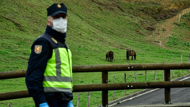 Spanish police officer blocks the road for vehicles to the border between Spain and France near the Pyrenees Spanish village of Dantxarinea.