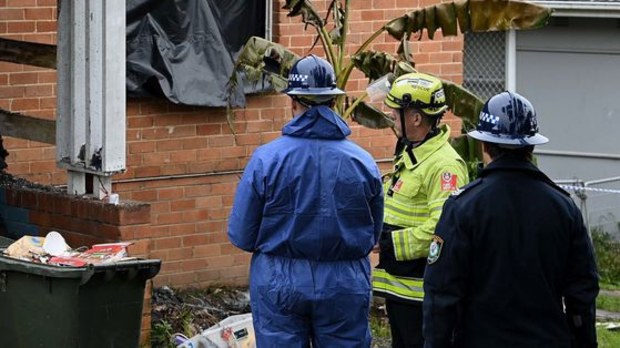 Police and fire crews outside of the Lalor Park home in Sydney's west where three children died in a fire in July.