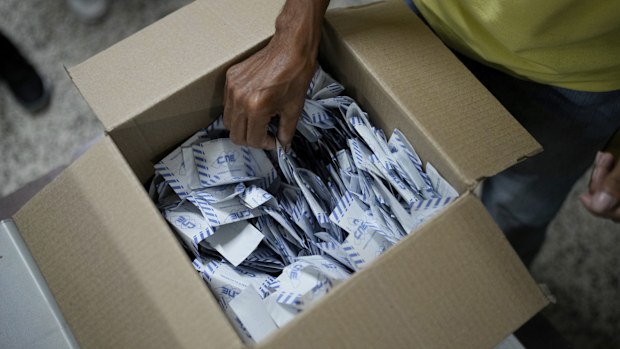 Electoral officials tally votes after polls closed for presidential elections in Caracas, Venezuela, Sunday, July 28, 2024. (AP Photo/Matias Delacroix)