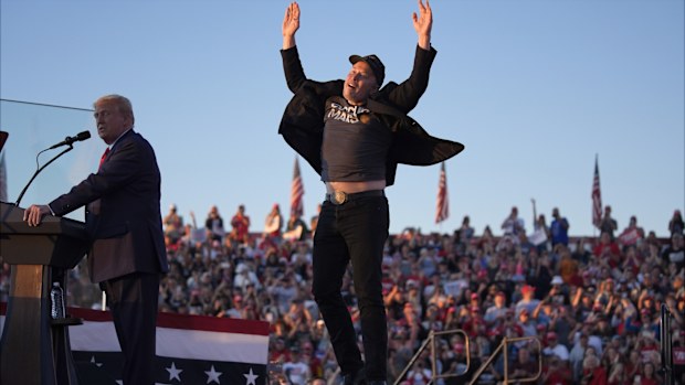 Elon Musk jumps on the stage as Republican presidential nominee former President Donald Trump speaks at a campaign rally at the Butler Farm Show, Saturday, Oct. 5, 2024, in Butler, Pa. 