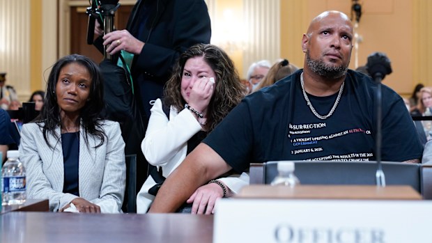 US Capitol Police Sargent Harry Dunn, right, Sandra Garza, the longtime partner of fallen Capitol Police Officer Brian Sicknick, center, and Serena Liebengood, widow of Capitol Police officer Howie Liebengood, left, react as a video of the January 6 attack on the US Capitol is played during a public hearing.
