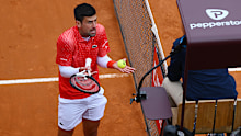Novak Djokovic of Serbia speaks with the umpire against Holger Rune of Denmark.