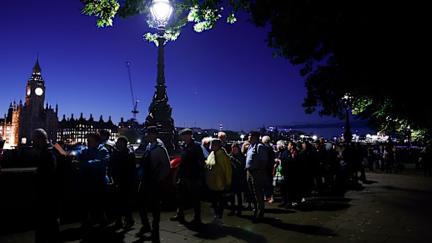 Members of the public stand in the queue in the evening for the Lying-in State of Queen Elizabeth II on September 16, 2022 in London, United Kingdom. Queen Elizabeth II is lying in state at Westminster Hall until the morning of her funeral to allow members of the public to pay their last respects. 