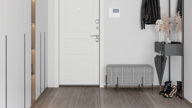 Front Door Entrance To House With Coat Hook,  White Cabinets, Hassock And Mirror In Corridor.