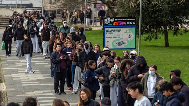 Staff and students, some wearing face masks, queue to receive antibiotics at the University of Kent in Canterbury after an outbreak of meningitis caused the deaths of two people, on March 16, 2026 in Canterbury, United Kingdom. 