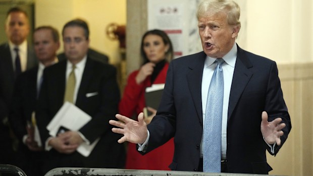 Trump, accompanied by members of his legal team, comments outside of his civil business fraud trial, Wednesday, Oct. 18, 2023.