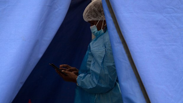 A healthcare worker waits to test people for 'COVID-19 at a facility in Soweto, South Africa