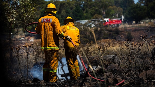 Fire crews are seen extinguishing an out of control grassfire in Melbourne